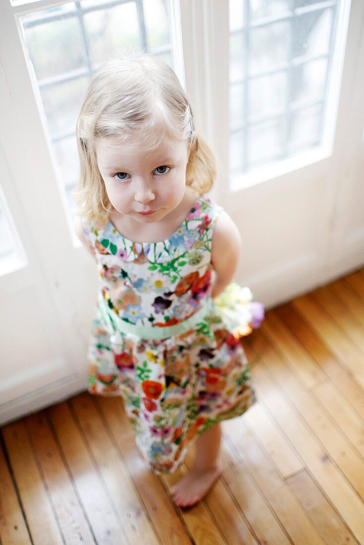 Portrait of a 3 years old girl, dressed in a flowered dress