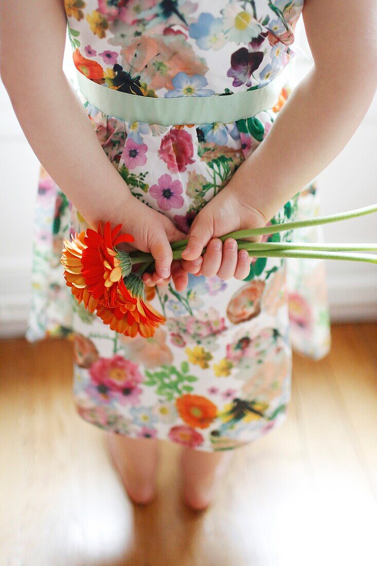 Closeup on hands of a little girl holding a flower bouquet