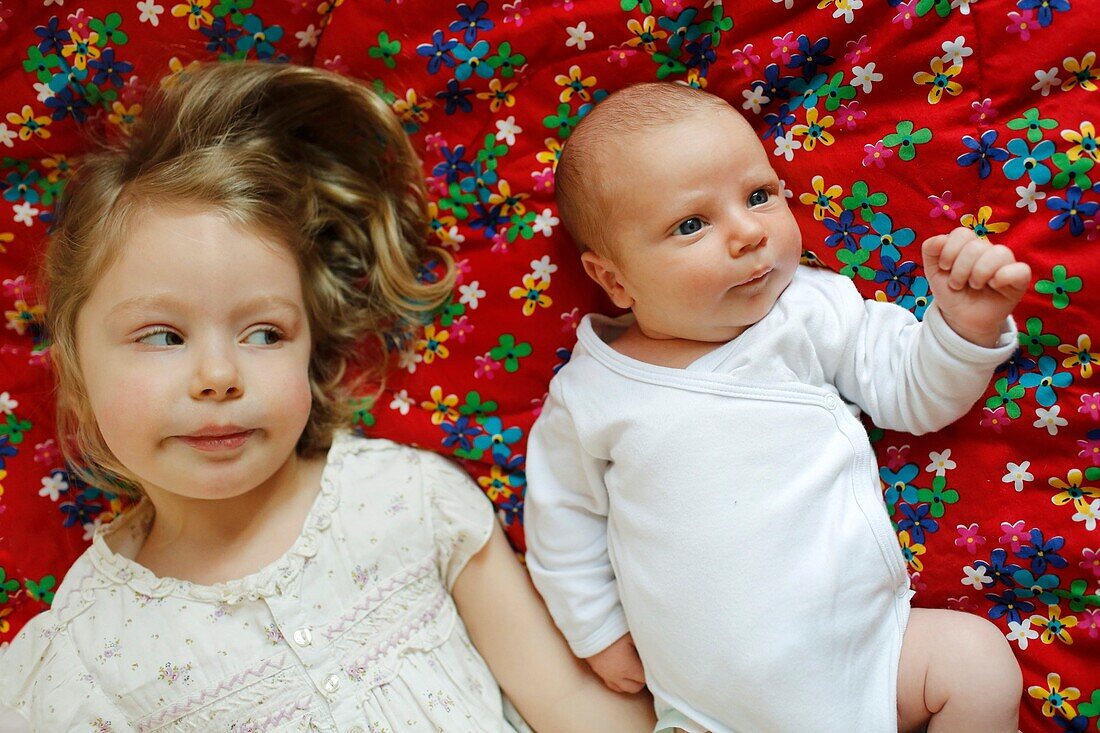A 3 years old girl posing with her newborn brother