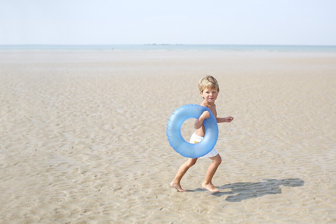 Little boy at the beach with his rubber ring