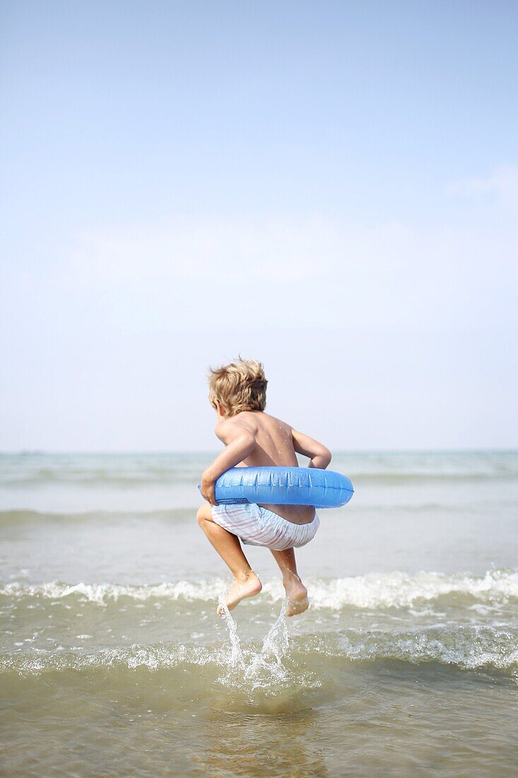 Little boy at the beach with his rubber ring