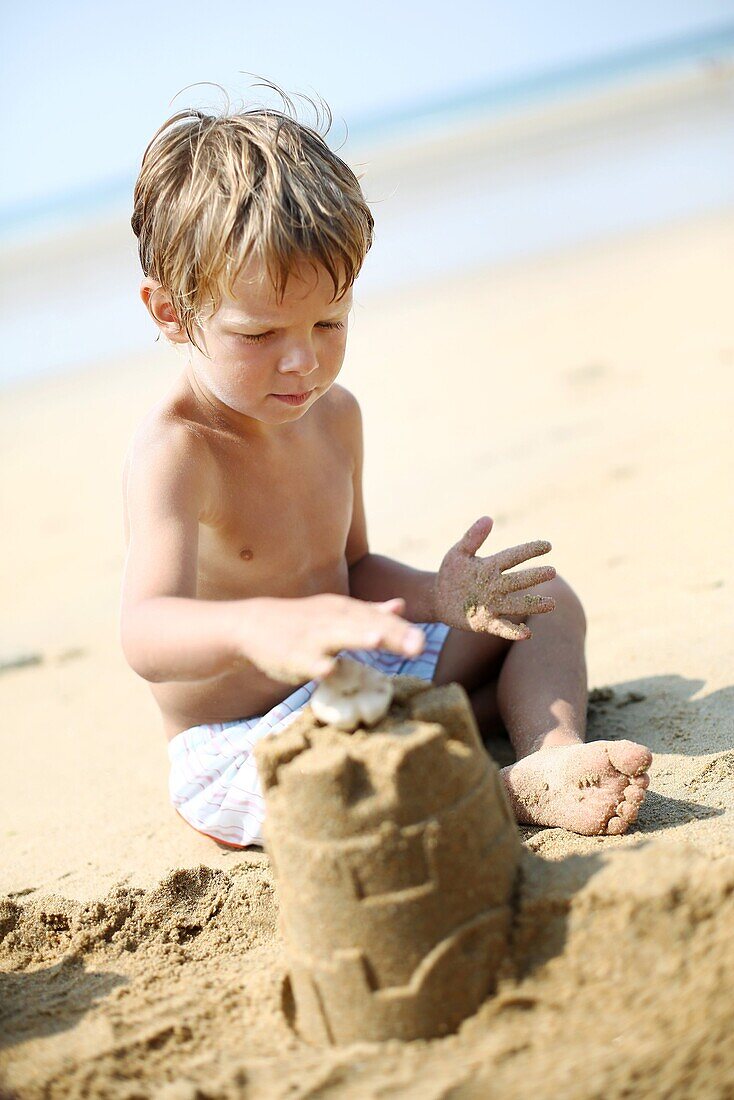 Little boy making a sand castle on the beach
