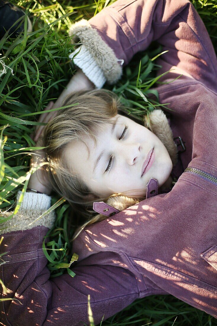 Portrait of a 10 years old girl lying in grass
