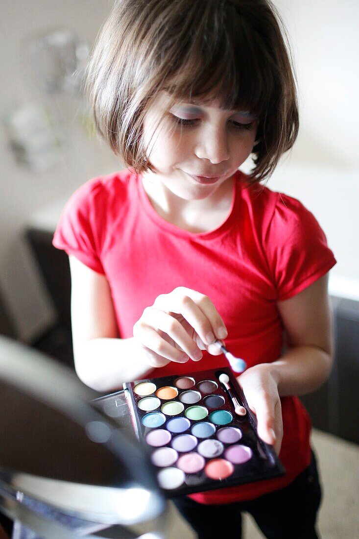 Little girl applying makeup
