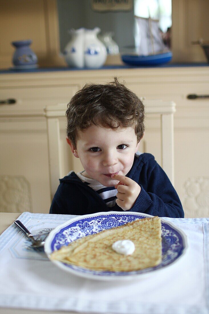 3 years old boy eating a crepe