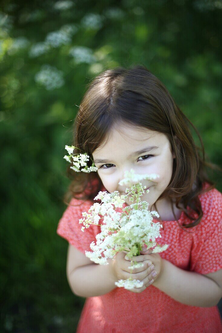 A 5 years old girl with flowers in the countryside