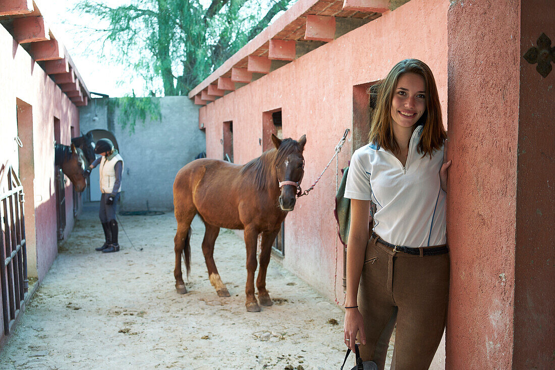 Woman smiling at horse stables on ranch