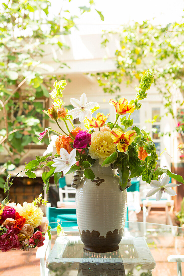 Blumenstrauß in Vase auf der Terrasse eines Hinterhofs