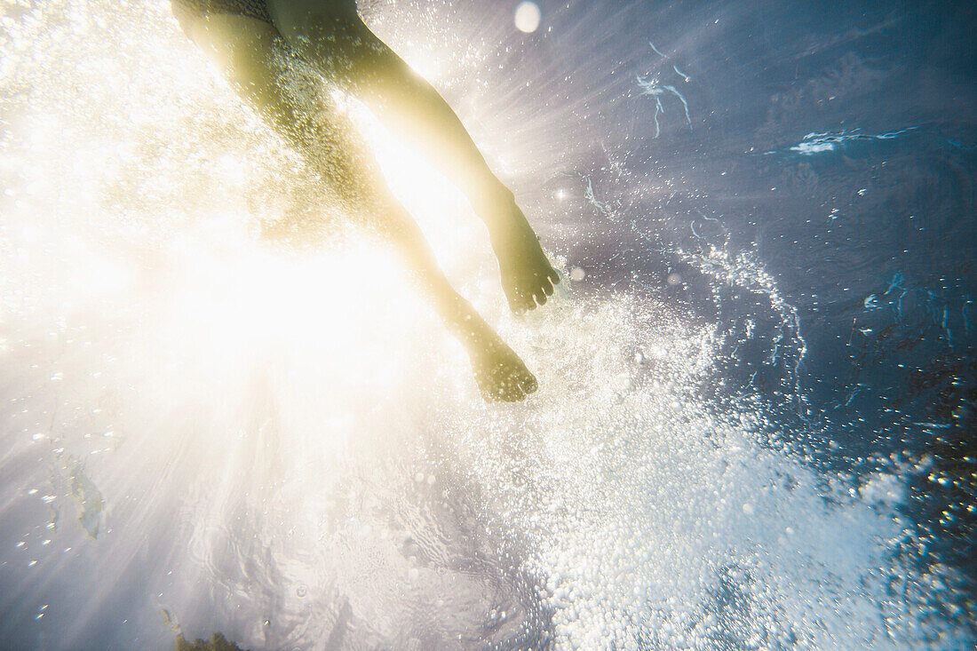 Caucasian girl swimming underwater in swimming pool