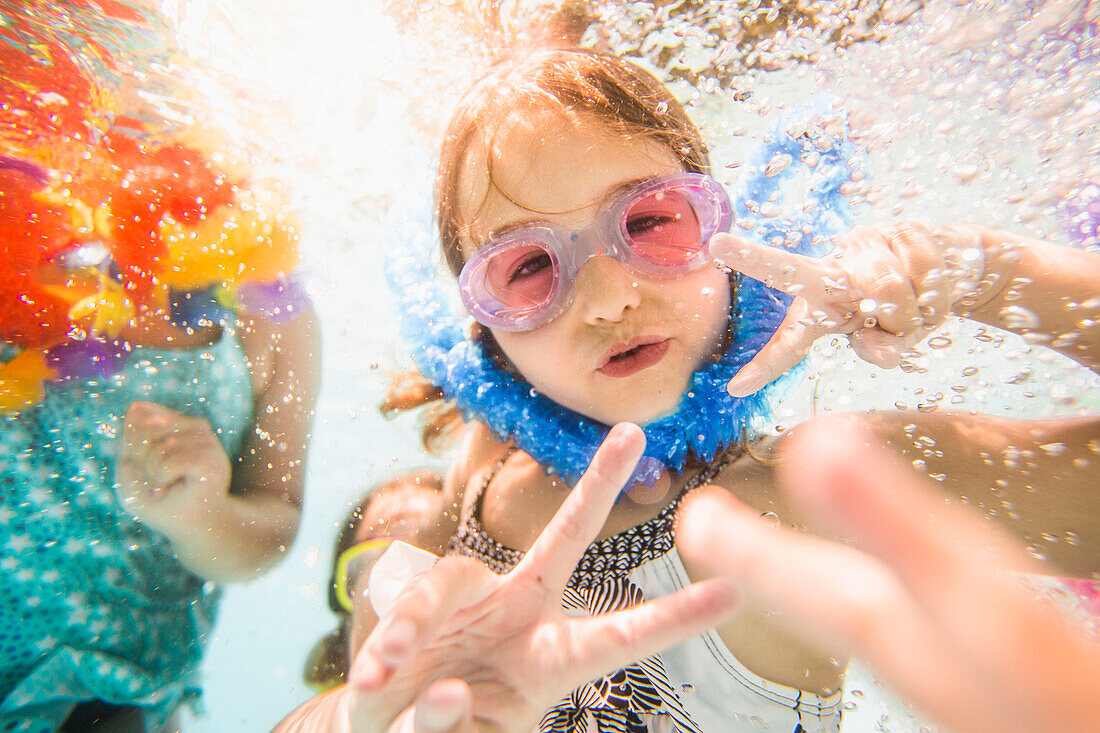 Caucasian children swimming underwater in swimming pool
