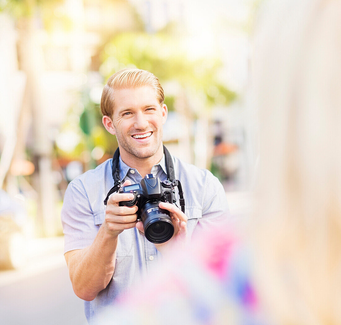 Caucasian photographer photographing woman outdoors