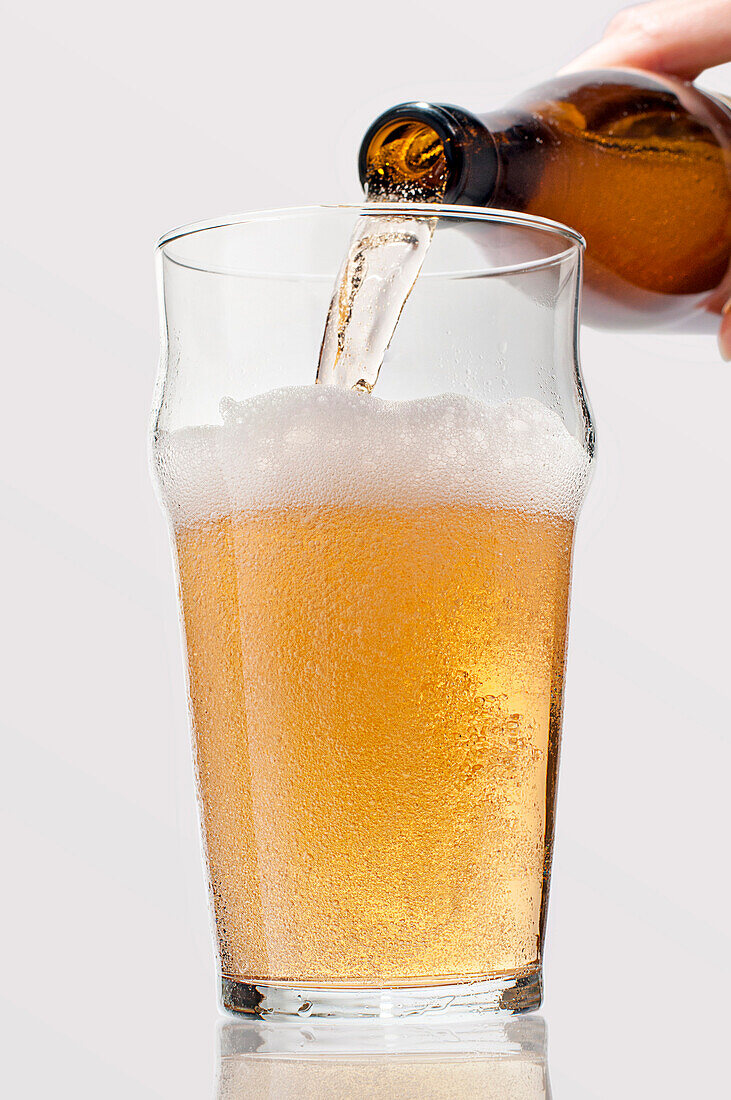 Man Pouring lager Beer into Glass, Close-Up