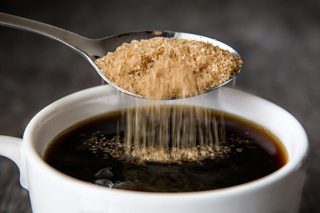 Brown Sugar Being Poured into Cup of Coffee, Close-Up