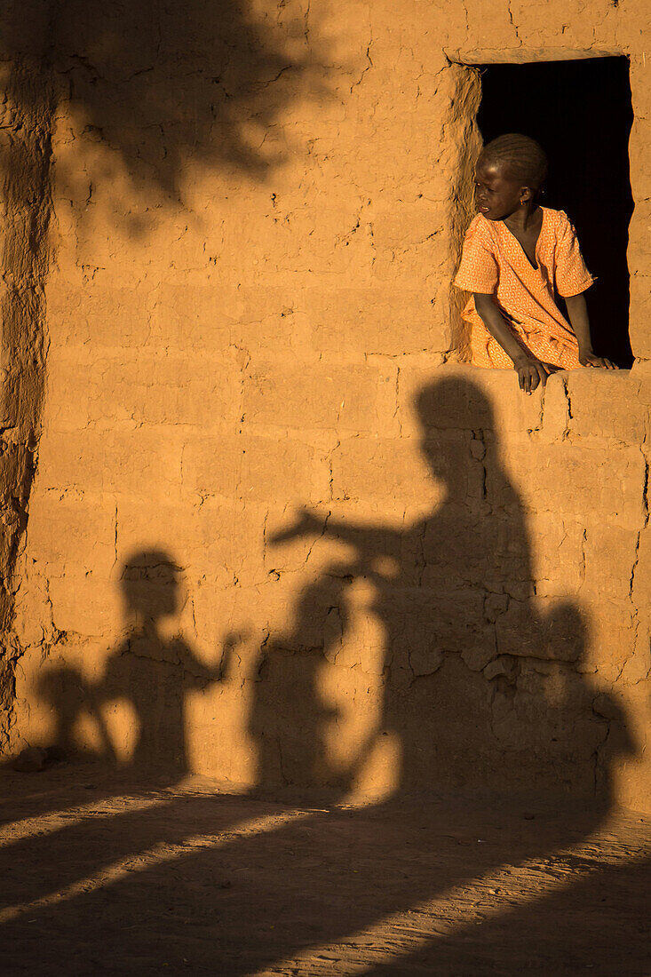 child and earthen houses in the village of toucouleur de deguembere, fanaye dieri province, senegal, west africa