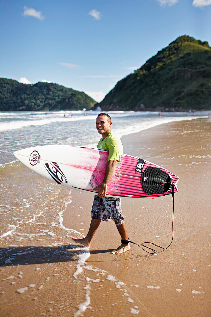 Surfer Rafael, 100% Jesus lettering on his board, Praia do Tombo, in the west of the city, Guaruja, Costa Verde, Sao Paulo, Brazil