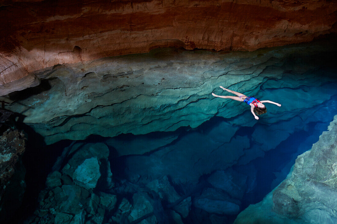 Luiza Voll aus Sao Paulo badet in Poco Azul, Sonnenstrahl, unterirdischer Fluss, archaeologische Fundstaette, oestlich des Chapada Diamantina National Park, Andarai, Bahia, Brasilien