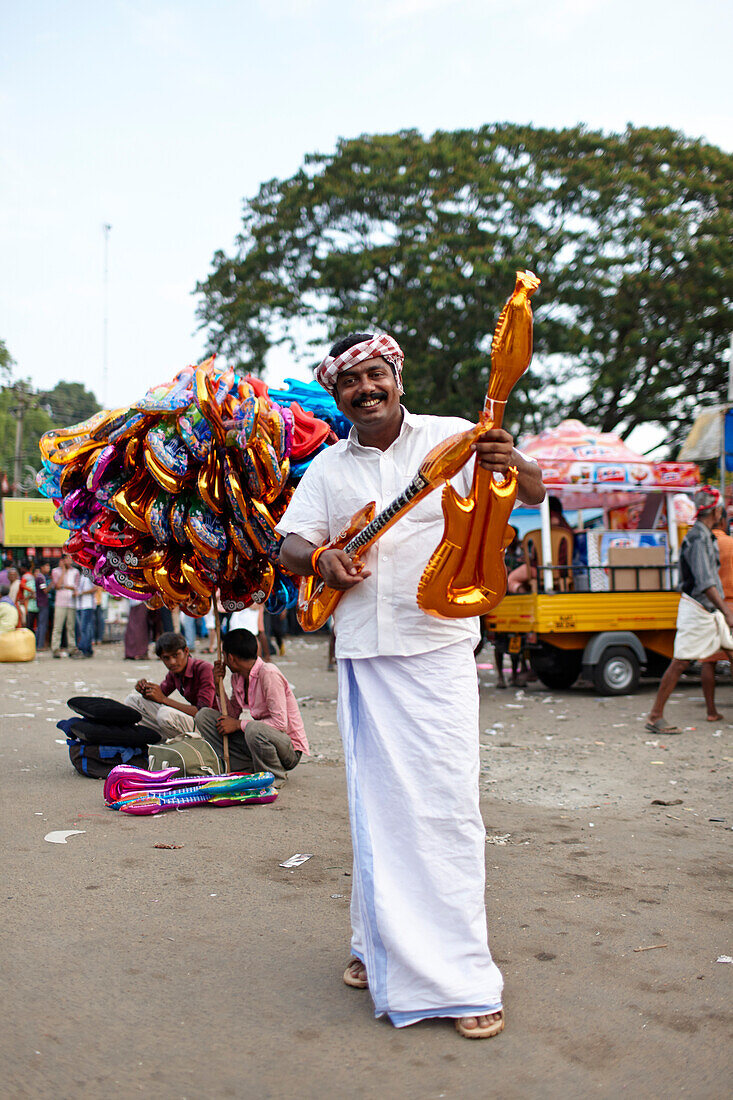 Besucher der Nemmara Vela, mit Luftballon-Gitarren, Vela ist ein Festival im Sommer nach der Ernte, Hindu - Tempel - Fest im Dorf Nemmara, bei Pallakad, Kerala, Indien