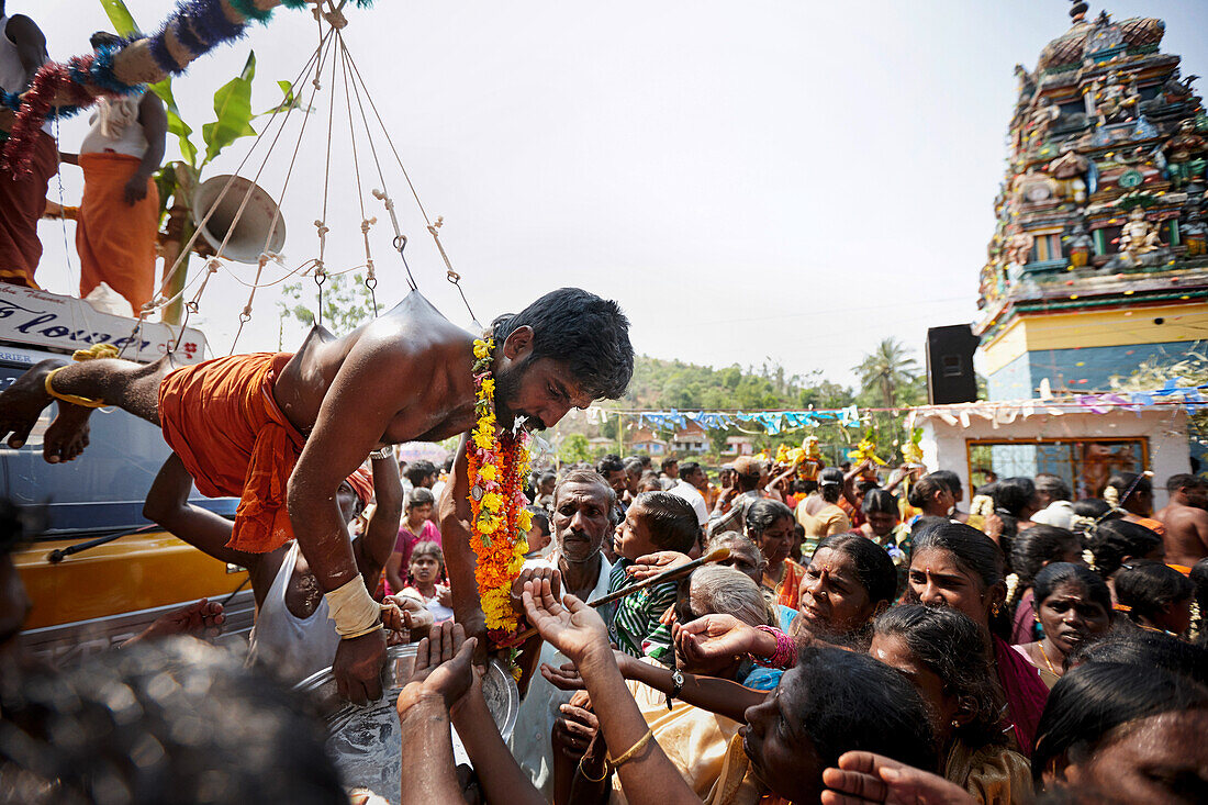Believer hanging on hooks, Sri Vinayagar temple festival, annual Hindu festival in the village of Nadukahni, northwest of the Nilgiri Hills (Ooty), Western Ghats, Tamil Nadu, India