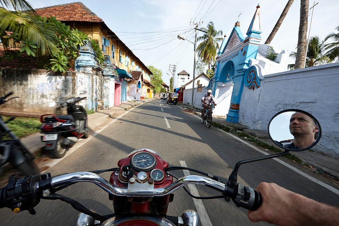 Photographer Hauke Dressler on a Royal Enfield motorcycle from 1986, Portuguese architecture along Bazaar Road in Fort Kochi, Cochin, Kerala, India