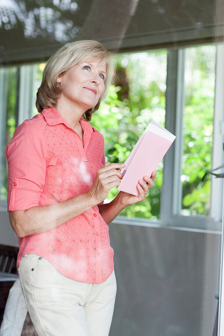 Smiling Caucasian woman reading card