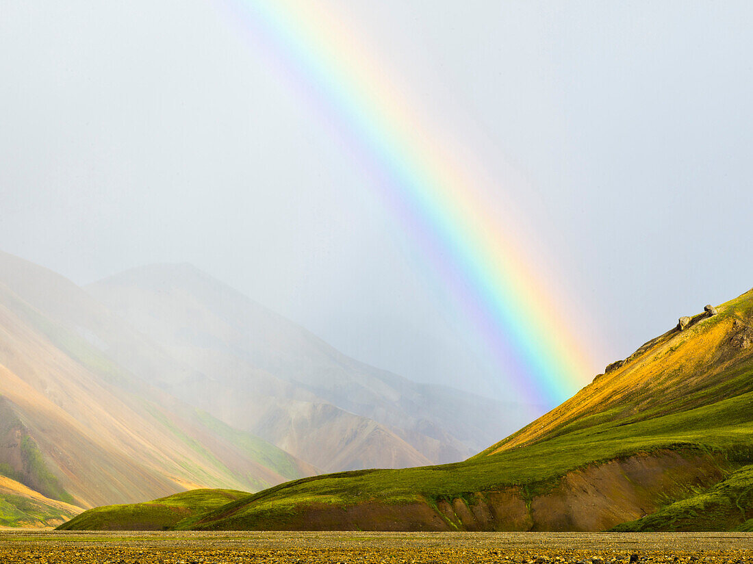 Rainbow over rural fields and hillside, Landmannalaugar, Fjallabak Nature Reserve, Iceland