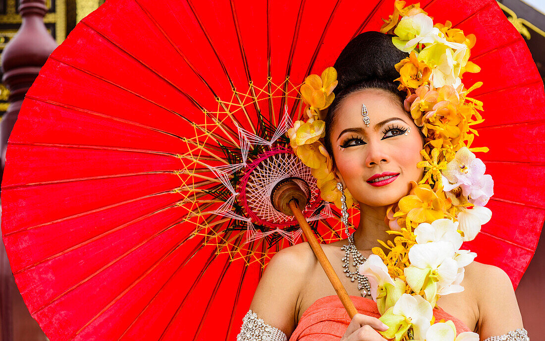 Asian woman with flower headdress holding parasol