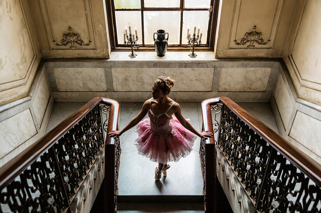 Hispanic ballet dancer standing on staircase