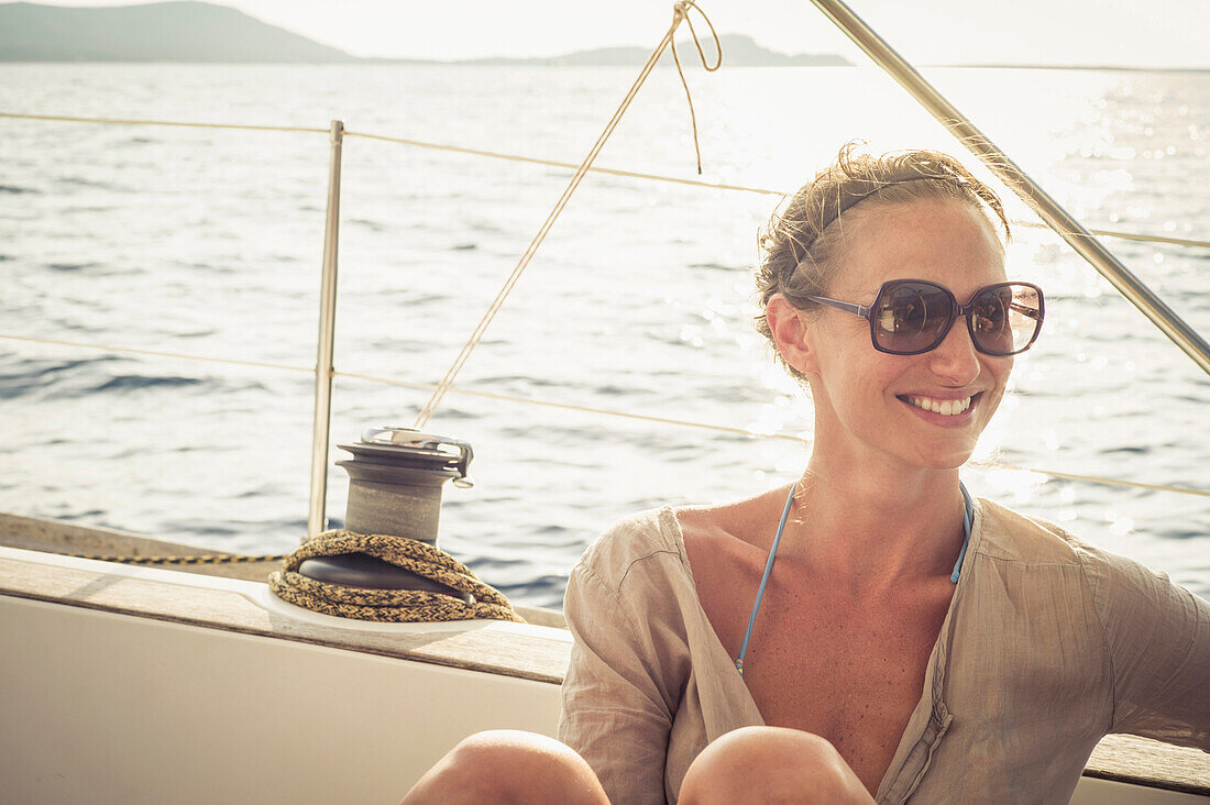 Smiling Caucasian woman sitting on boat deck
