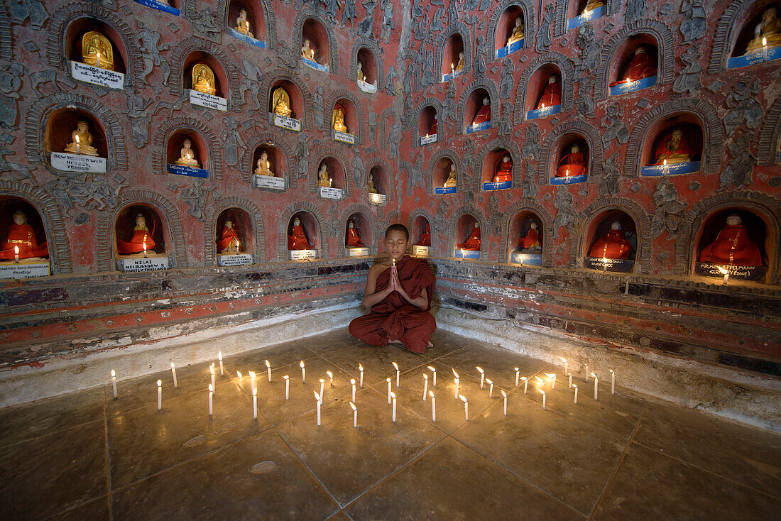 Asian monk-in-training praying in ancient temple