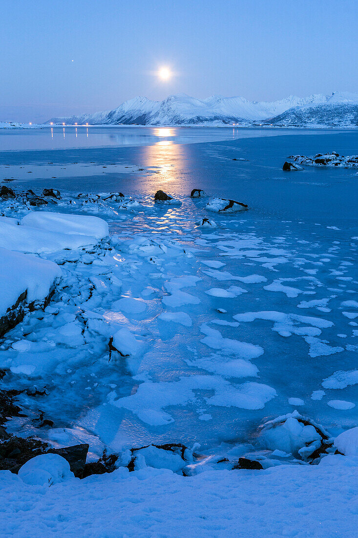 Reflections of full moon in the frozen sea, Lyngedal, Lofoten Islands, Arctic, Norway, Scandinavia, Europe