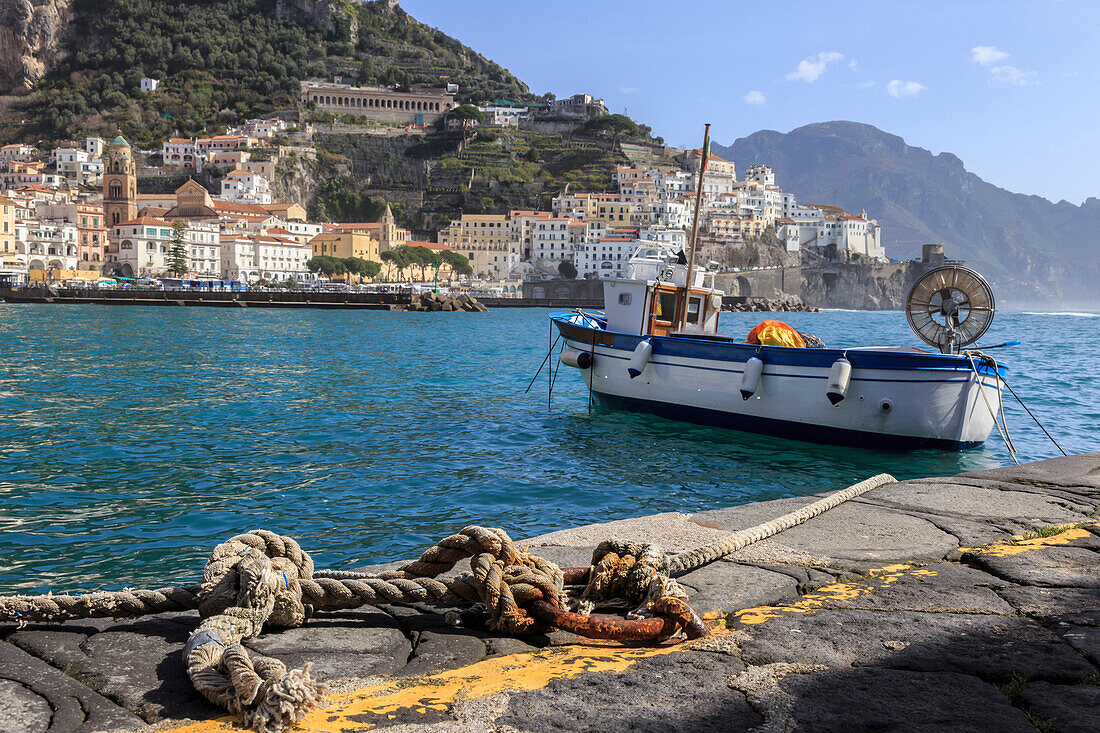 Tethered fishing boat with rope, Amalfi harbour, from quayside with view towards Amalfi town, Costiera Amalfitana (Amalfi Coast), UNESCO World Heritage Site, Campania, Italy, Europe