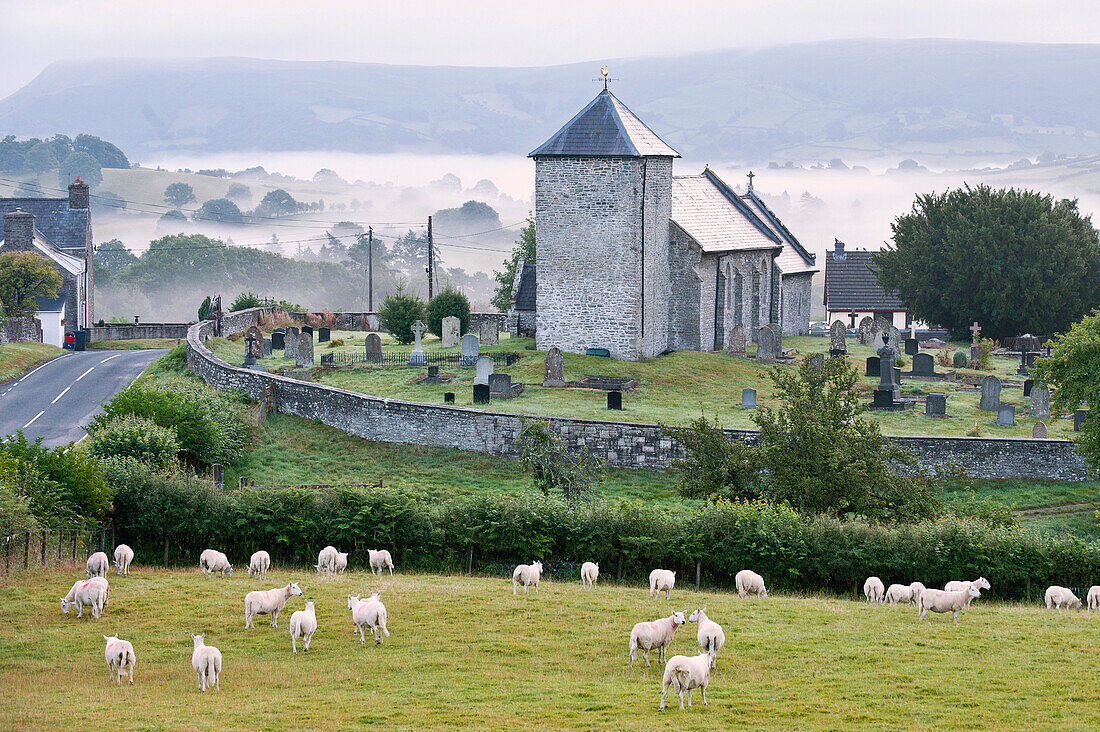 Early morning mist in the valleys surrounds St. David's Church, Llanddewi'r Cwm, Powys, Wales, United Kingdom, Europe