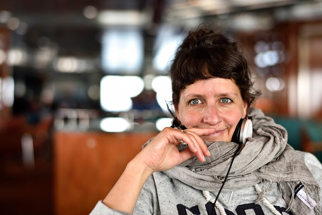 Frau mit Kopfhörer im Café, Blick in die Kamera, Hamburg, Deutschland