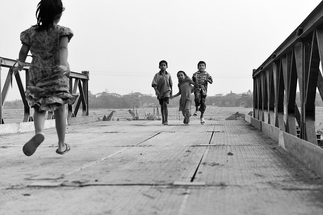 Kinder spielen auf einer kaputten Brücke in Munshiganji, Bangladesch