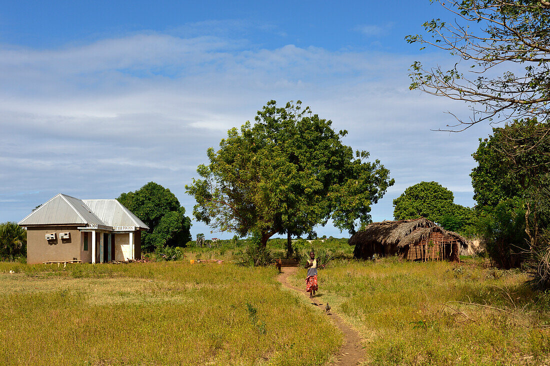Ein Mädchen rennt auf einem Weg vom Wohnhaus in Kigamboni, Tansania, Afrika