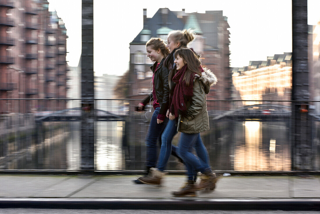 3 Mädchen unterhalten sich draußen in der Specherstadt, Hamburg,  Deutschland, Europa