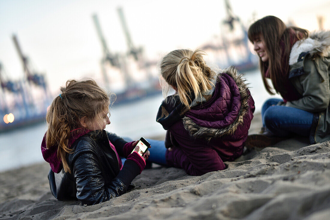 3 Mädchen blicken auf den Hafen am Elbstrand, Övelgönne, Hamburg, Deutschland, Europa