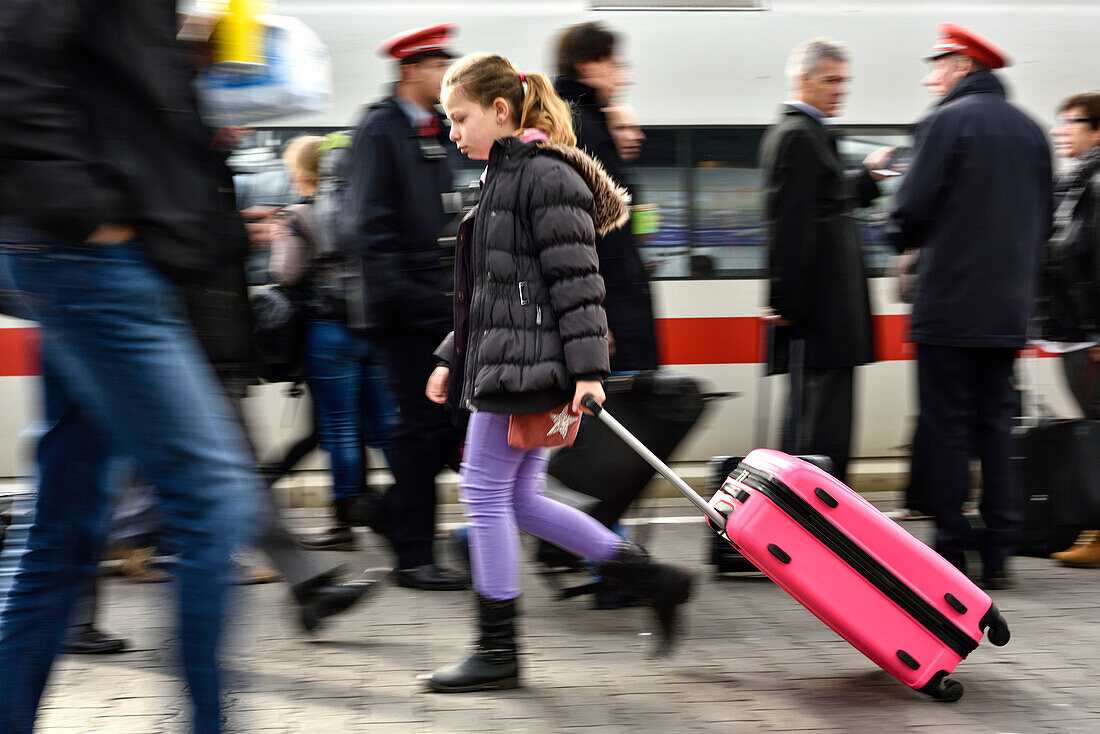 Mädchen mit Koffer läuft über den Bahnsteig im Zuggleis, München, Bayern, Deutschland, Europa