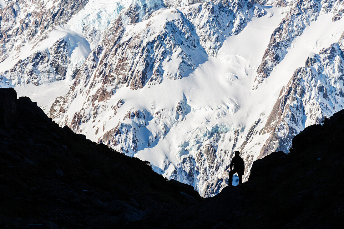 Silhouette of hiker on snowy mountain slope