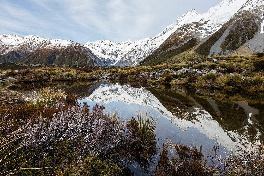 Snowcapped mountains reflecting in remote lake, Mount Cook Village, Mckenzie Country, New Zealand
