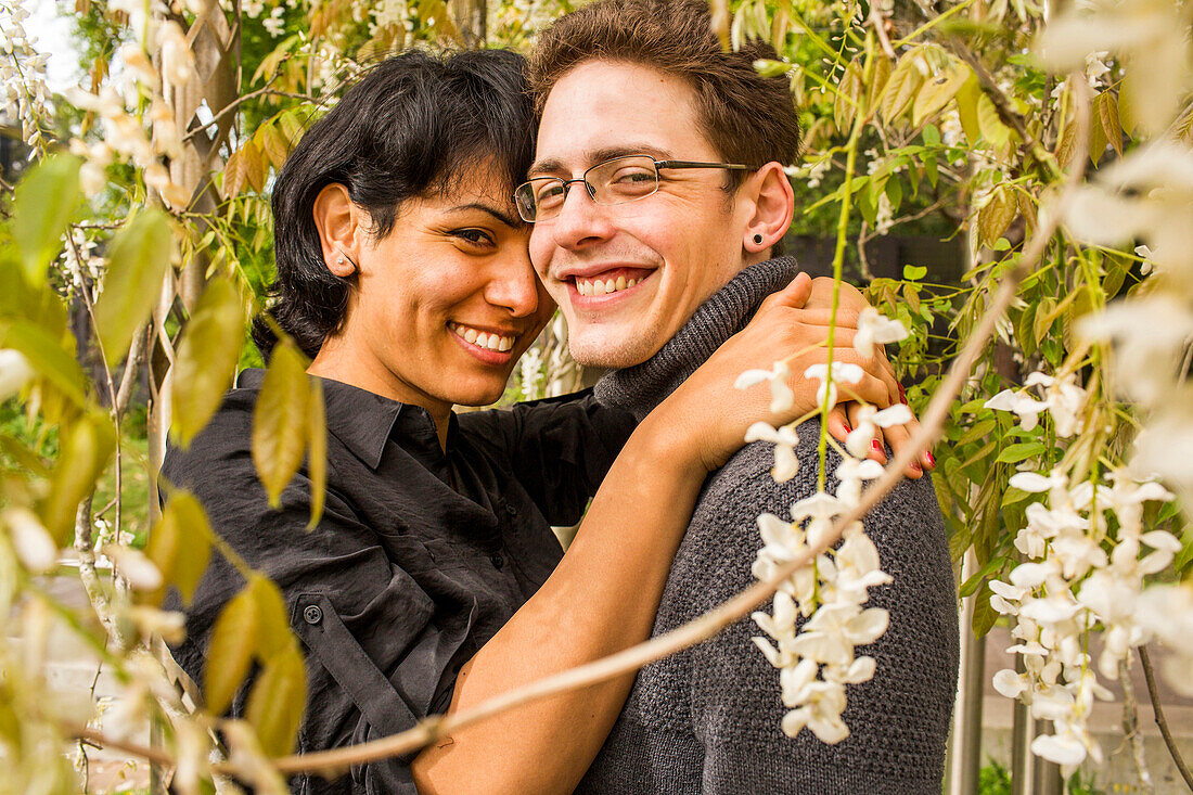 Smiling couple hugging in foliage