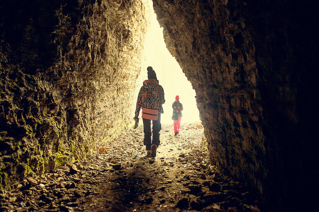 Caucasian hikers walking in rocky cave