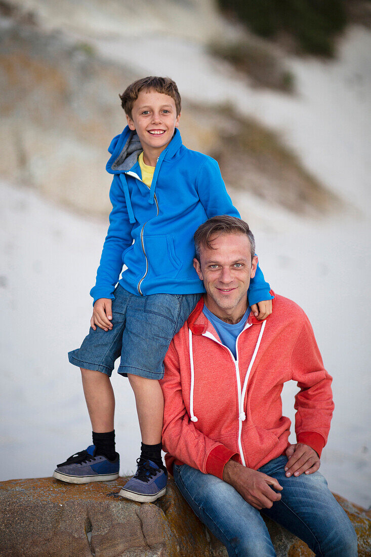 Caucasian father and son smiling on beach