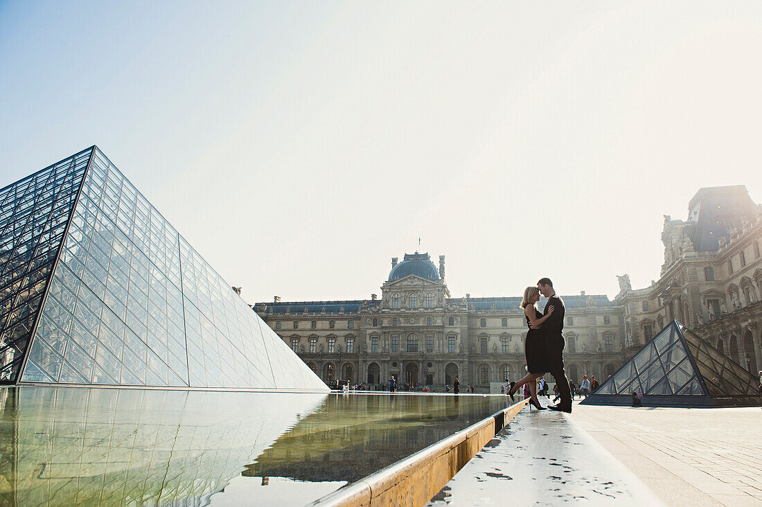 Caucasian couple kissing near ornate building, Paris, Ile-de-France, France