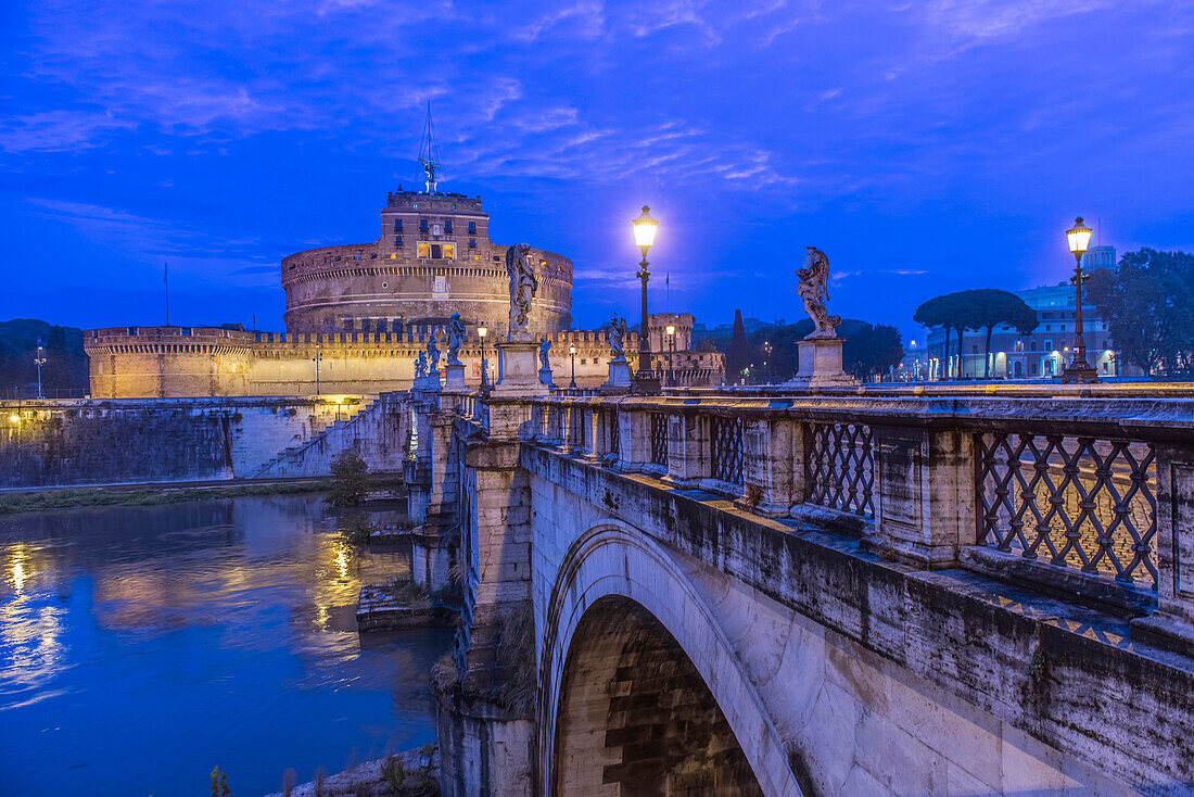Ornate bridge and Ponte Sant'Angelo illuminated at night, Rome, Italy