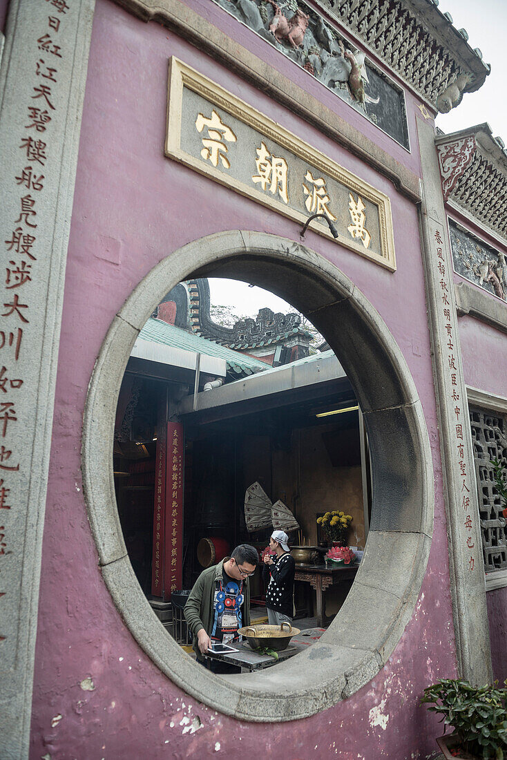 chinese man lays down iPad to pray, A Ma temple, Macao, China, Asia