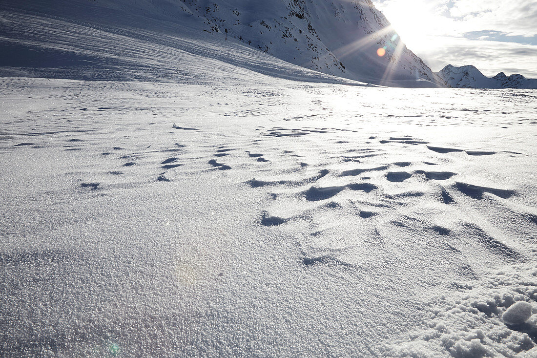 Schneeoberfläche mit Bergen im Gegenlicht, Schnalstal, Südtirol, Italien