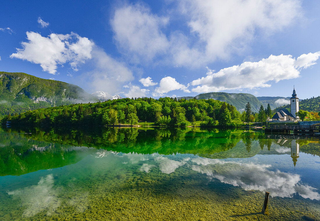 reflection at Lake Bohinj, with mountains and medieval church, Ribcev village, Stara Fuzina, Bohinj, Gorenjska, Julian Alps, Triglav National Park, Slovenia, Europe