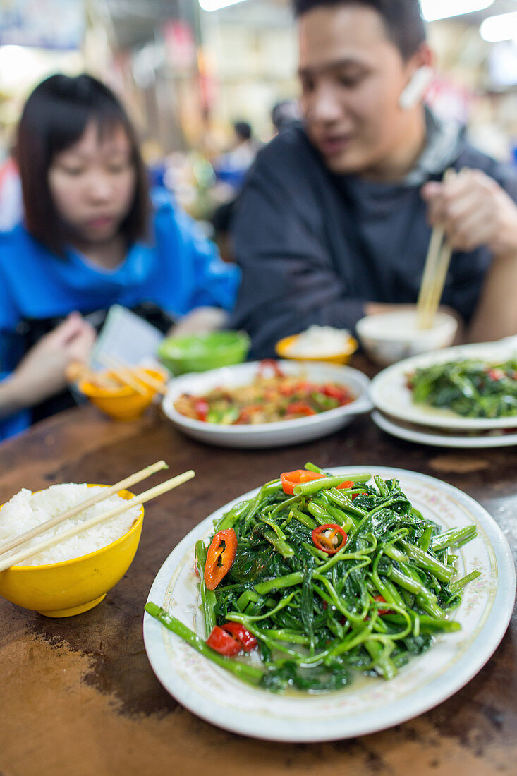 Reis mit Stäbchen und Gemüse, junge Leute, Paar, Wokgemüse, Essen im Food Court, Wok, Restaurant, Hong Kong Island,  China, Asien