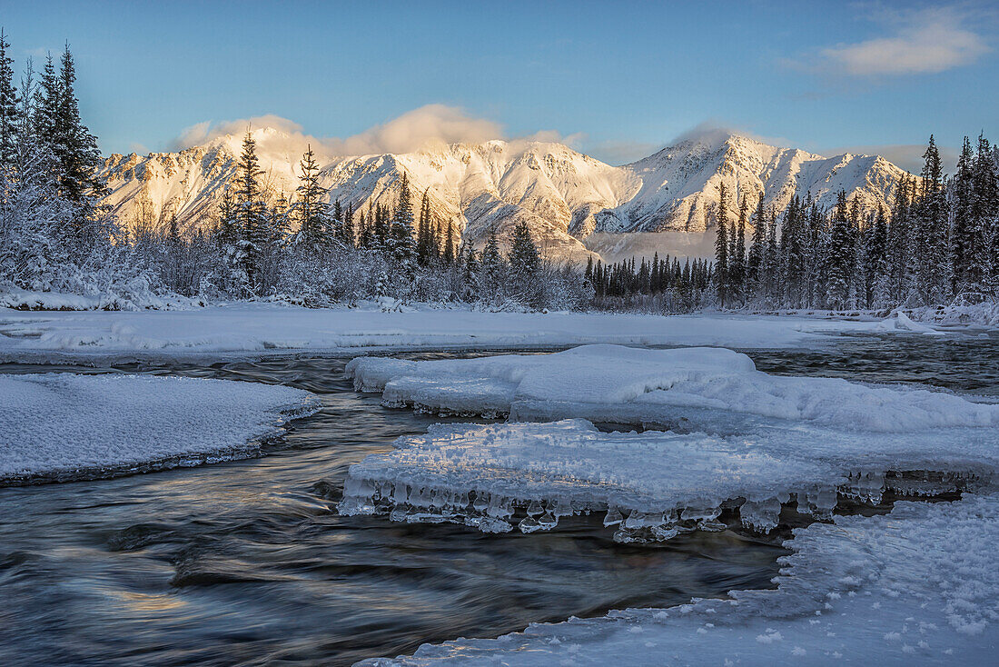 Sunset over the Wheaton River as the light hits Grey Ridge, near Whitehorse, Yukon, Canada